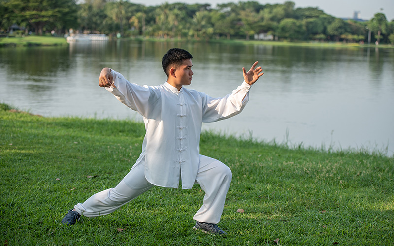 Man practicing slow Tai Chi outdoors to balance Yin and Yang