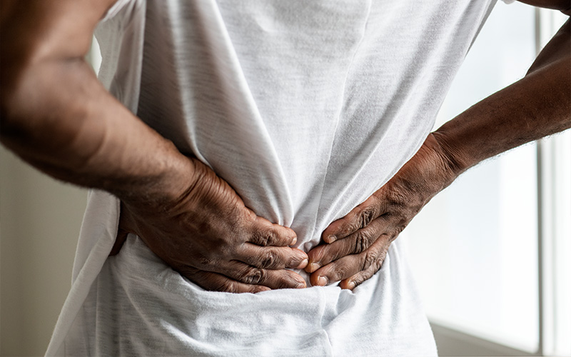 Man clutching his lower back in pain.